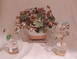 Delicate enameled metalwork floral arrangements, the larger center piece in warm fall colors, the smaller two in pastels.