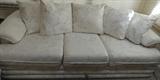 White on white foliage patterned fabric sofa with loose pillow back.