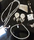 Selection from jewelry, rhinestone, freshwater pearl, Anne Klein, Mexican sterling, Italian sterling, enameled, chains, everyday watches, artisan rhinestone studded cuff and earrings on white leather, more.