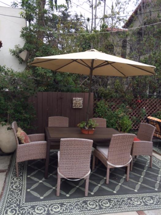 designer patio table with 8 chairs and waterproof rug and unbrella