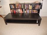 Pair of 3 tiered black bookcases with contemporary long black flat screen TV stand in front
