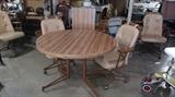 Butcher block style round kitchen table with one large leaf. Comes with 4 swivel chairs on rollers.