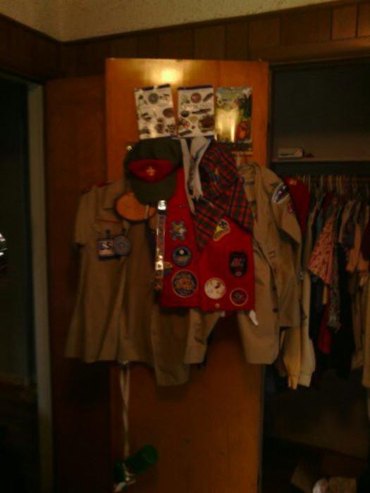 here we have two scout shirts two handkerchiefs a scout hat a scout belt a red scout leader berret and several scout books and a fire saftey plaque
