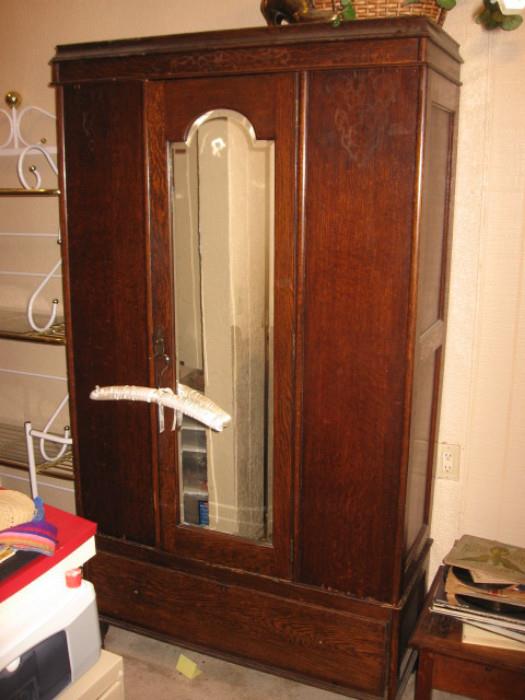 Antique armoire w/beveled dressing mirror in door.