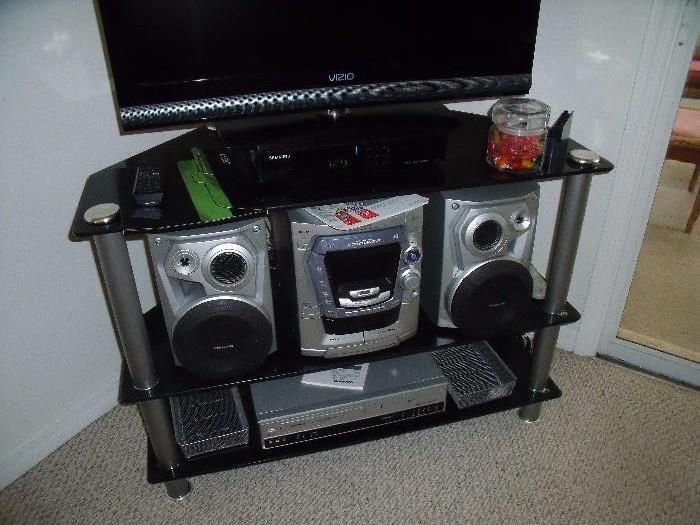 Modern low media stand with Panasonic compact stereo system and Daewoo DVD/video tape player