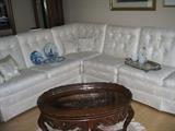 white sectional sofa. Coffee table with glass top over eagle.