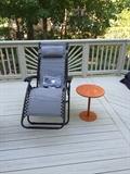 Lounger with orange round metal side table