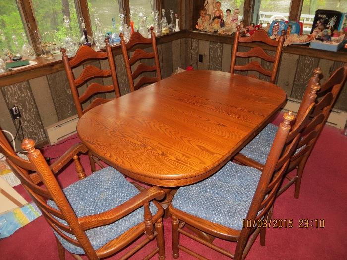  1980's,Oval Oak/chestnut table with one extension leaf, two arm chairs and 4 ladder back style side chairs, in like new condition