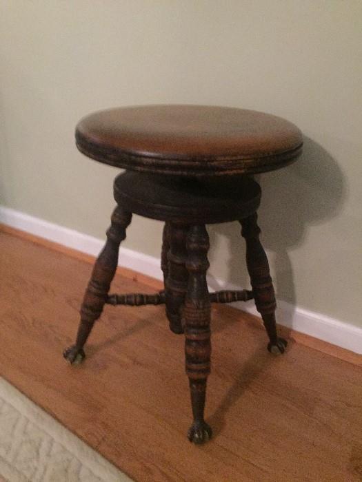 This amazing piano stool has claw feet holding clear glass marbles