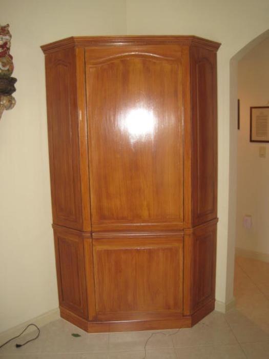 Corner wardrobe with several wood rods inside.  It is a beautiful piece.