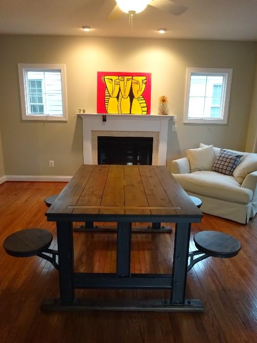 The desk converted into a dinning table with swivel chairs that hide under the table.The table is hard wood and iron. Its in excellent condition.