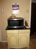 Silver microwave and cabinet below