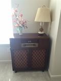 vintage floor radio, no phonograph.  Vase with artificial flowers; table lamp.