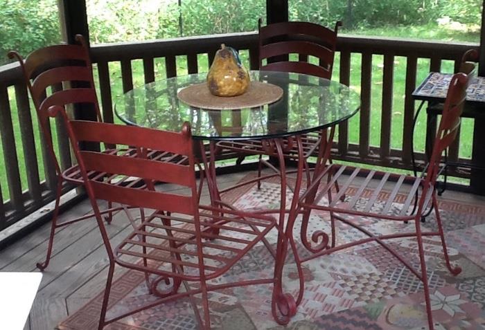 glass and iron table with 4 red metal chairs