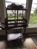 Antique rabbit cage atop a vintage tea cart with removable tray