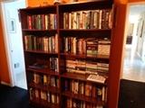 Several wooden bookcases loaded with books for sale