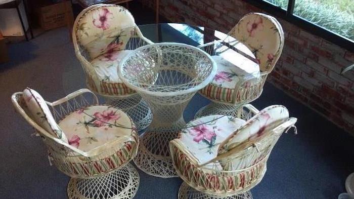 Fiberglass patio table (29" tall) with glass top (48" diameter) and four chairs (two of which swivel). Tan color of table base and chairs runs throughout so no chips, cracks, fading or peeling. The Wicker Place - South Beach Collection. Cushions made by Calico Corner.