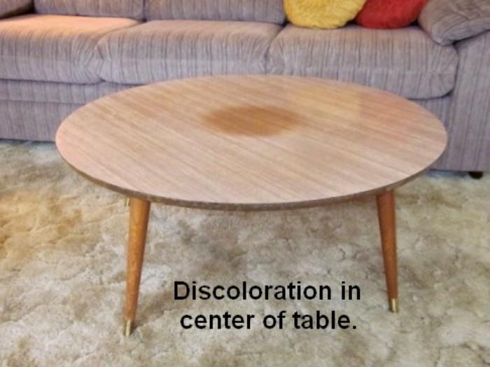 Mid Century Modern round coffee table with pencil legs and laminate top.  Top has a discoloration in the middle and one leg needs repair.