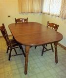 Solid wood kitchen table (laminate top) with one leaf and five solid wood chairs (1 arm chair and 4 side chairs).