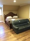 Full size bed and green leather sofa
